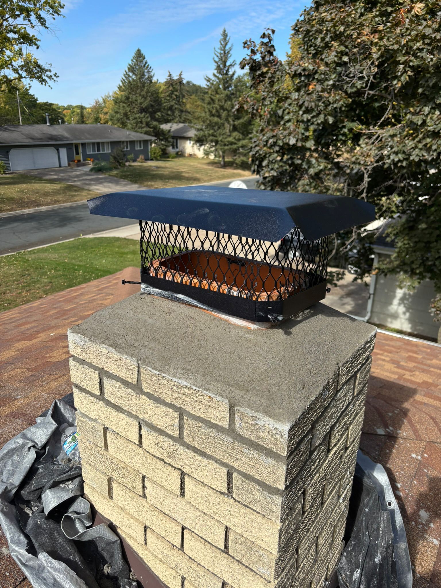 JB Chimney Services technician inspecting a factory-built metal chimney on a Bloomington, MN suburban home near the Minnesota River.