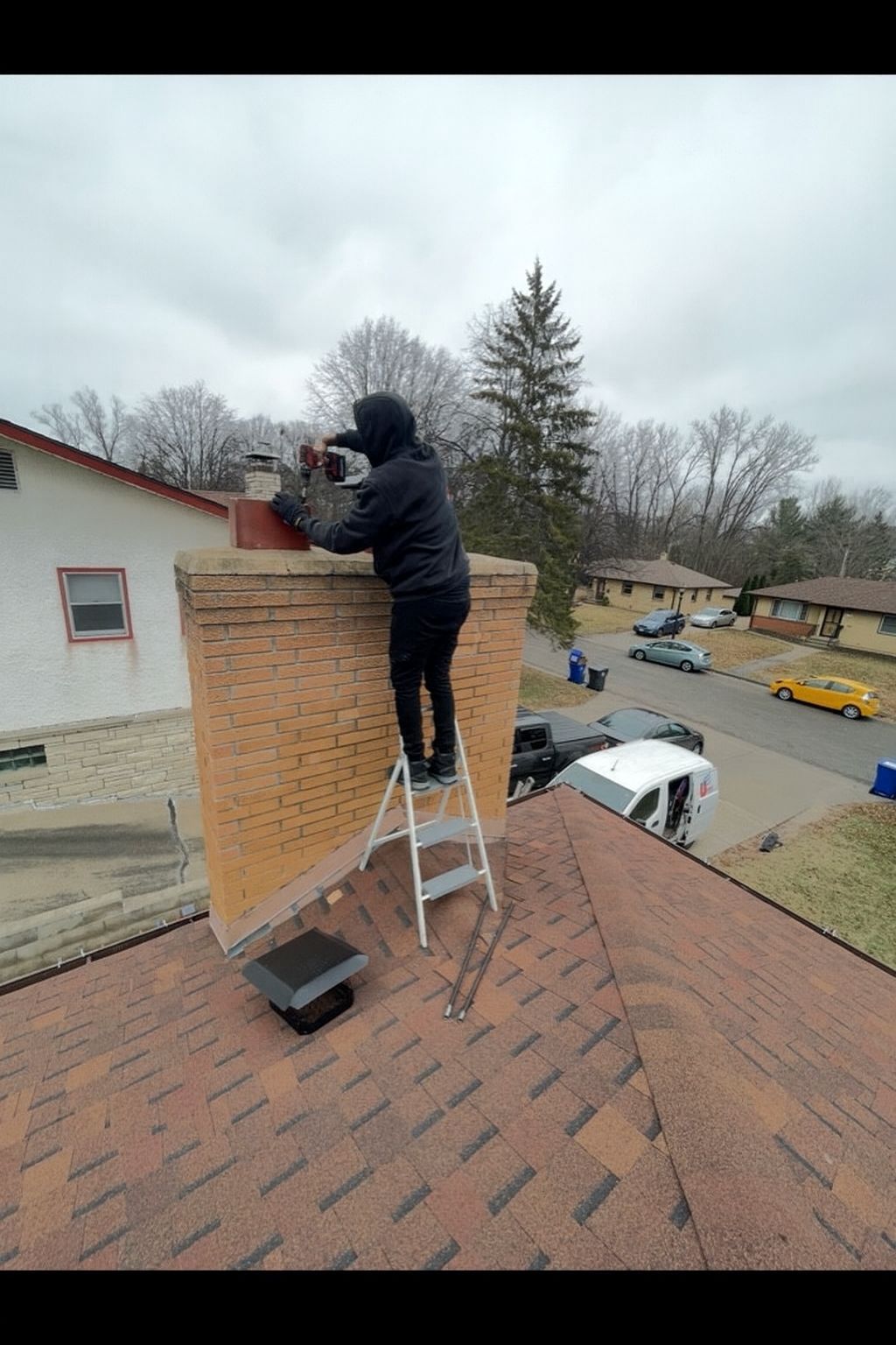 JB Chimney Services bricklayer replacing worn mortar joints on a residential chimney in New Brighton, MN.